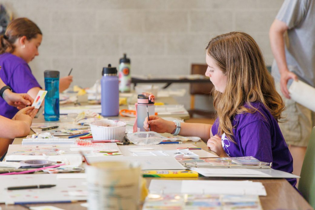 Campers at art table painting