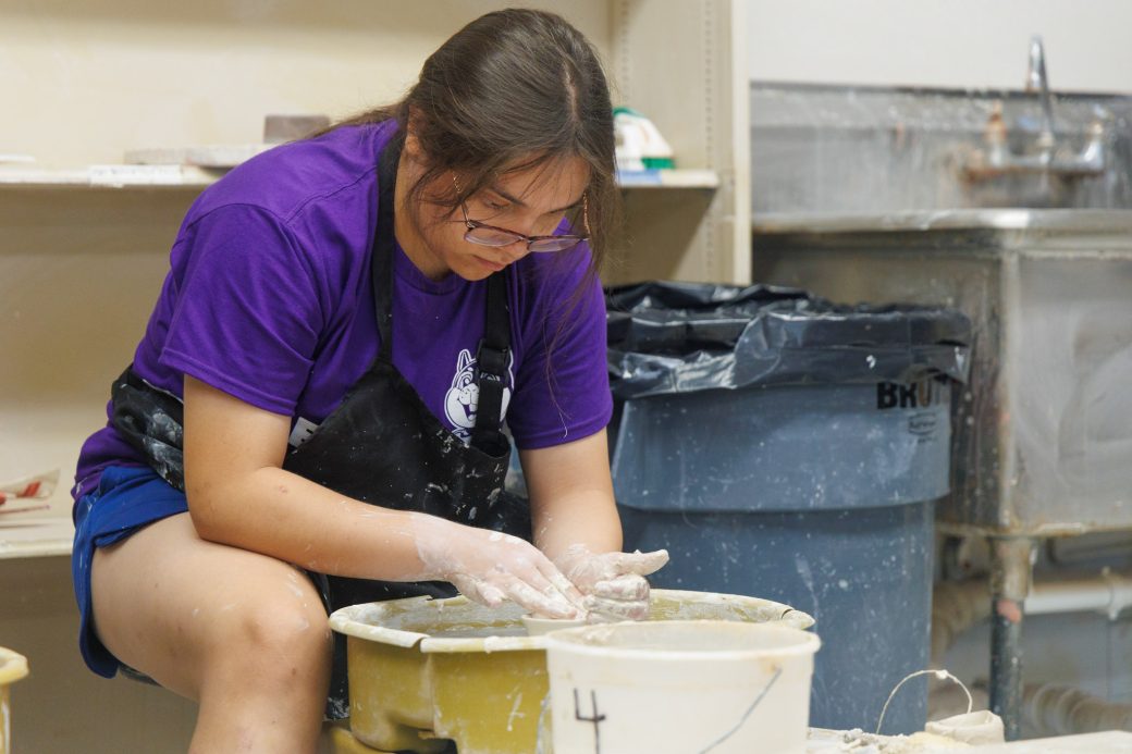 Summer camp staffer throwing on the wheel