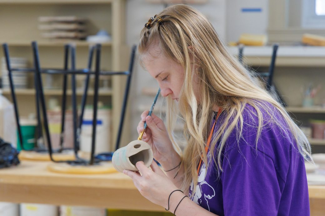 Close up of student building clay with hands