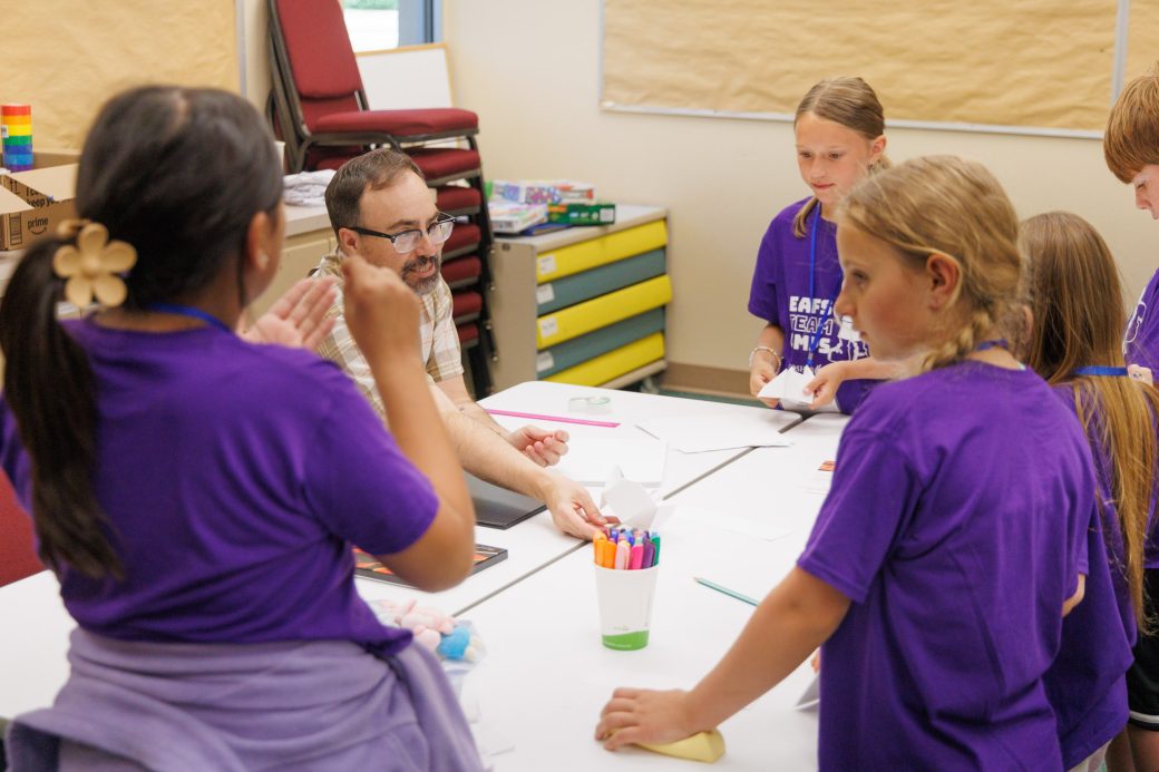 Summer campers learning with teacher