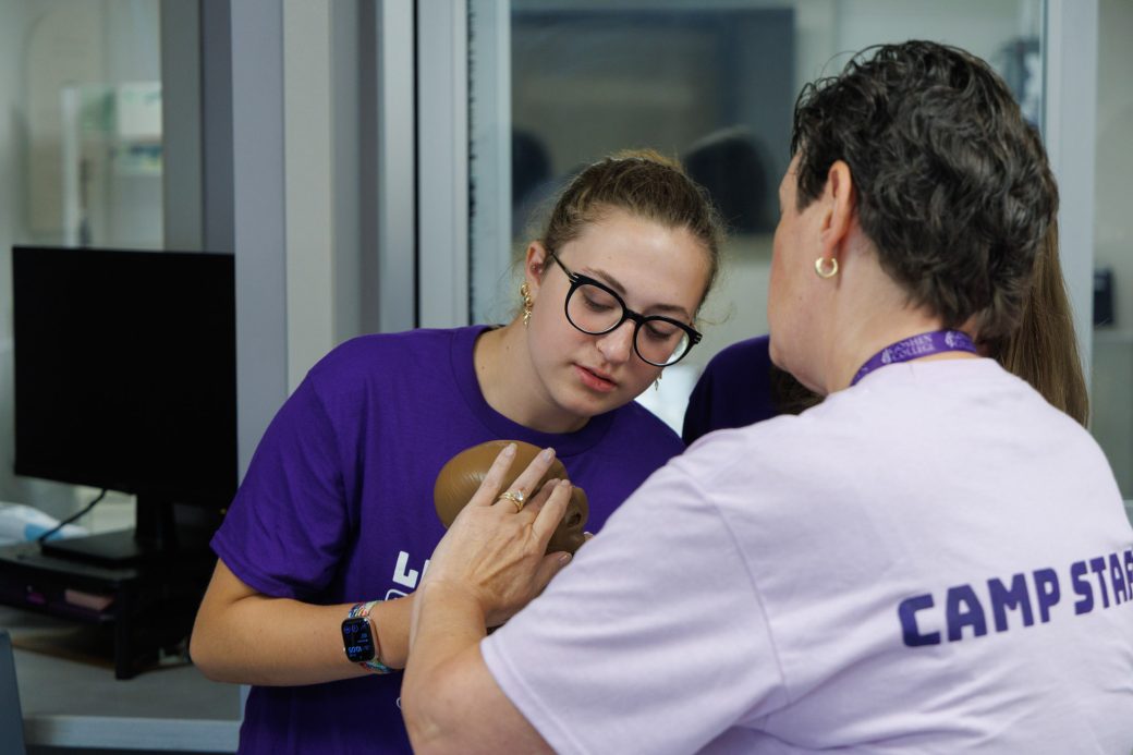 Nursing students looking closely at baby mannequin