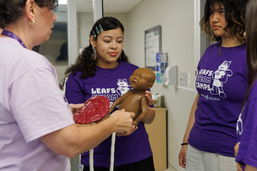 Teacher showing students baby mannequin