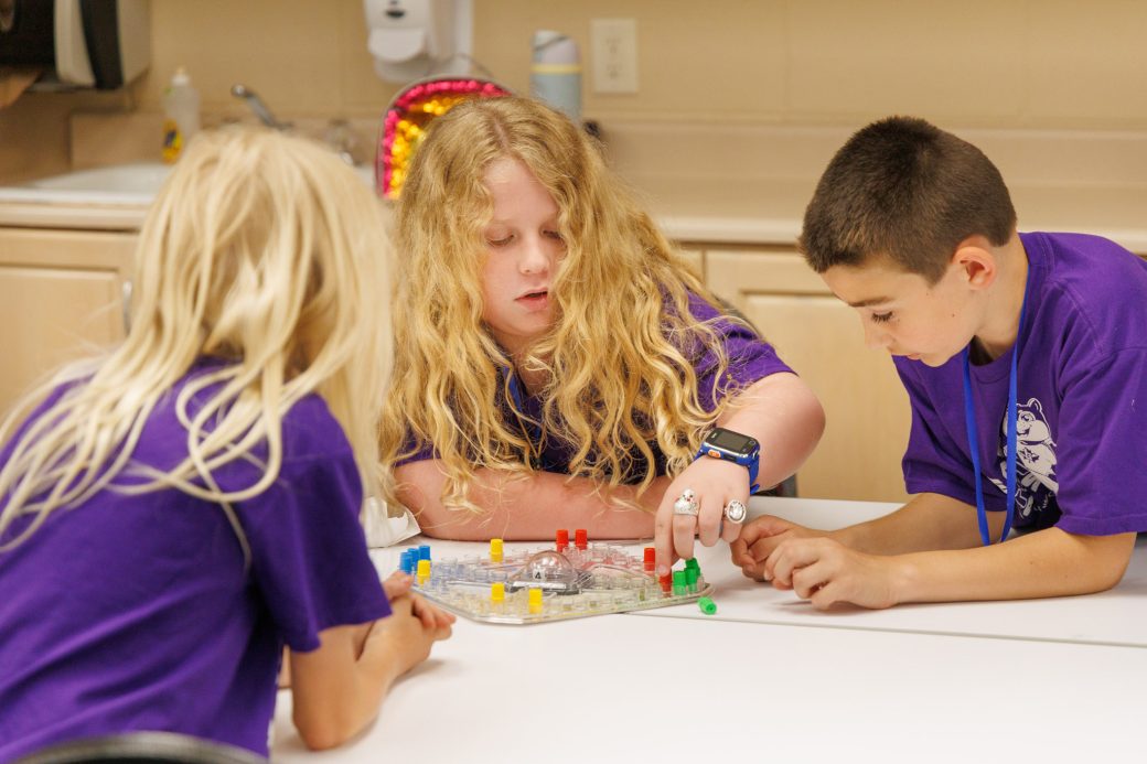 Three campers playing board game