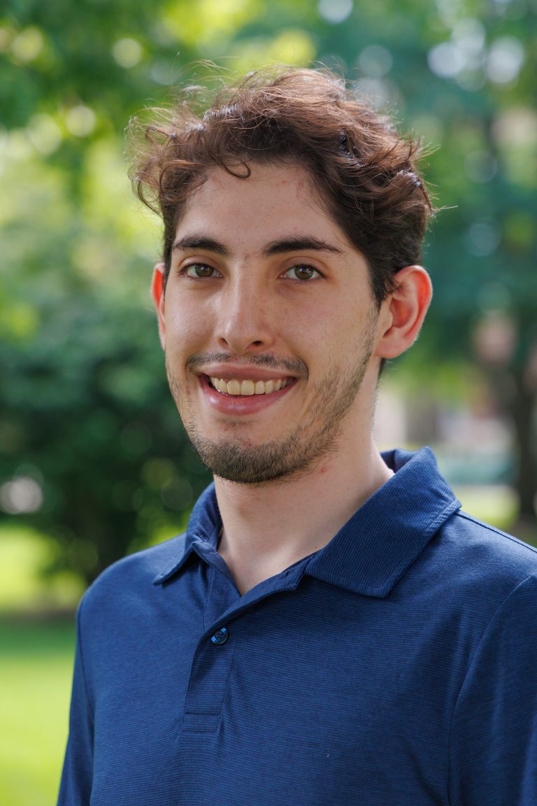 professsional headshot of Adrian Candia-Ayllon wearing a blue collared polo shirt.