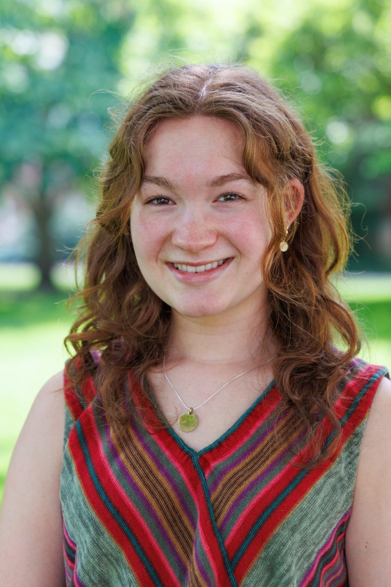 Professional headshot of Julia Miller wearing a multi-color v-neck top.