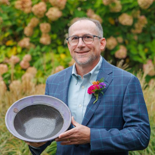 Jonathan Shenk holding the 2026 Servant Leadership Award outside.