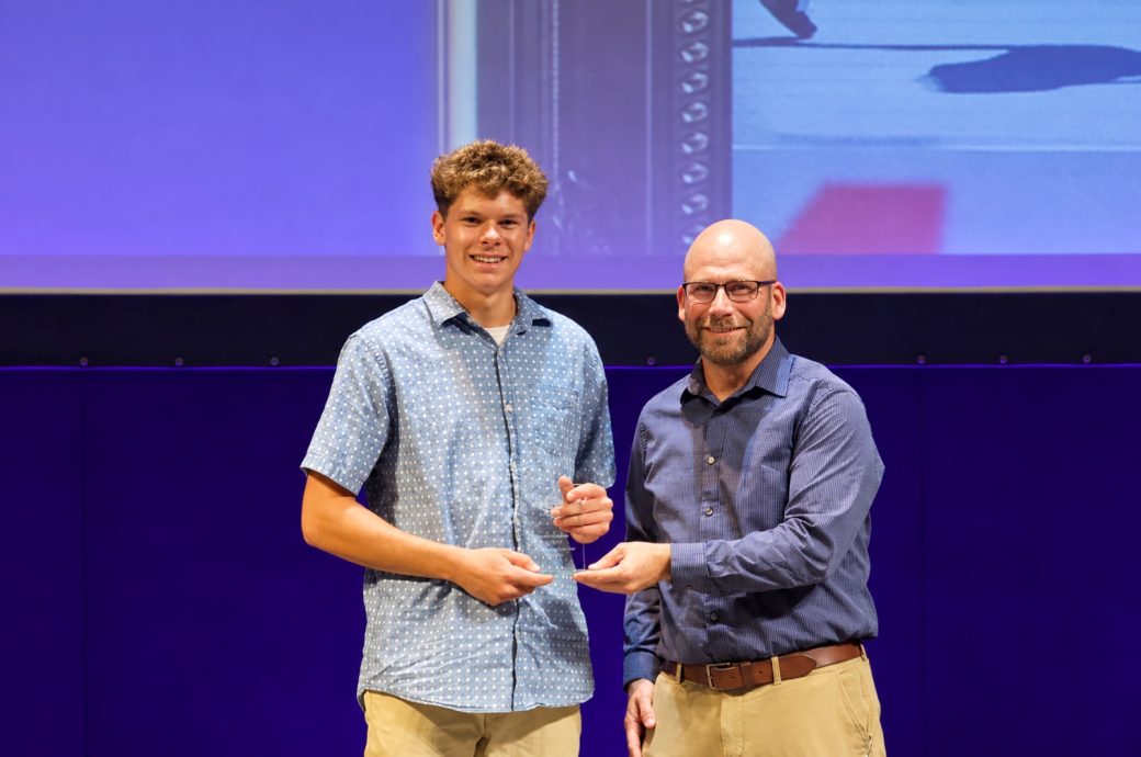 Neal Friesen giving an award to a student
