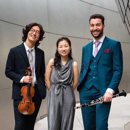 Trio Caspar in front of grey concrete building.