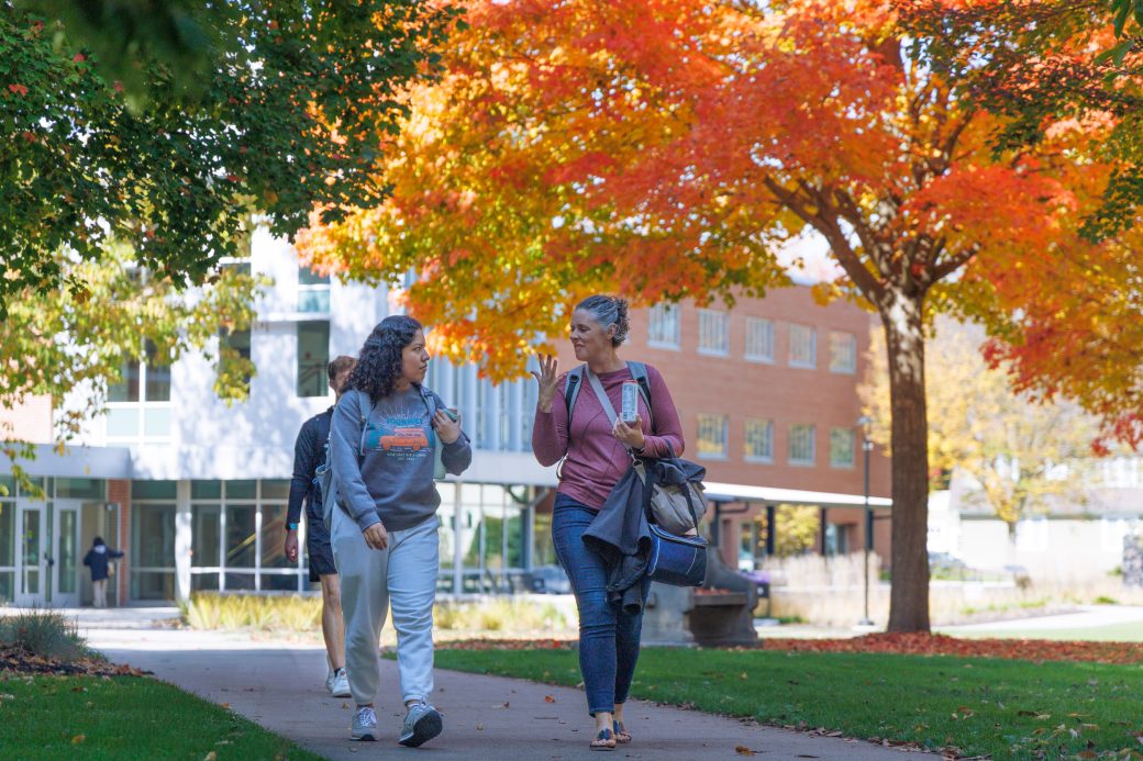 Student and ASL translator walking on campus in fall