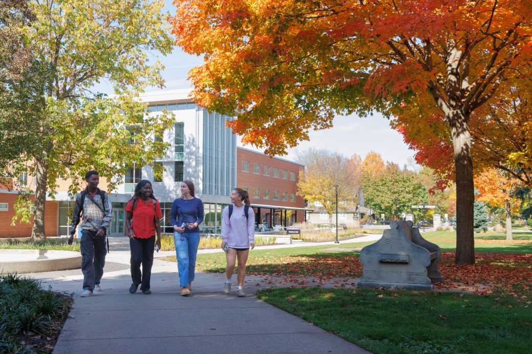 Group of students walking by the fountain in fall