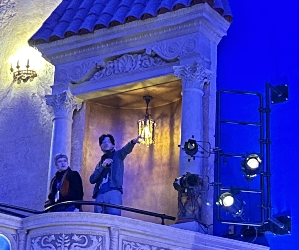 Two people looking around on a theater balcony