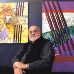 Man sitting in front of two paintings