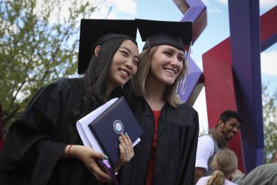 Two students in graduation caps and gowns at Goshen College graduation