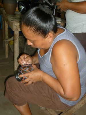 Azucena, wife of Juan Paulino, etches a design into a hand-made ceramic pot