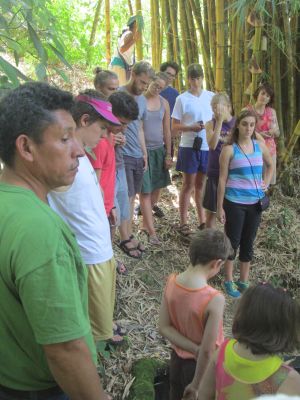 Students learn about the only fresh, clean water source in the area-part of what makes Vicente's farm so coveted.