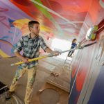 Noah Yoder painting underpass mural