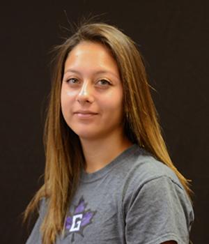 Woman in gray shirt with Goshen College purple leaf logo, smiling