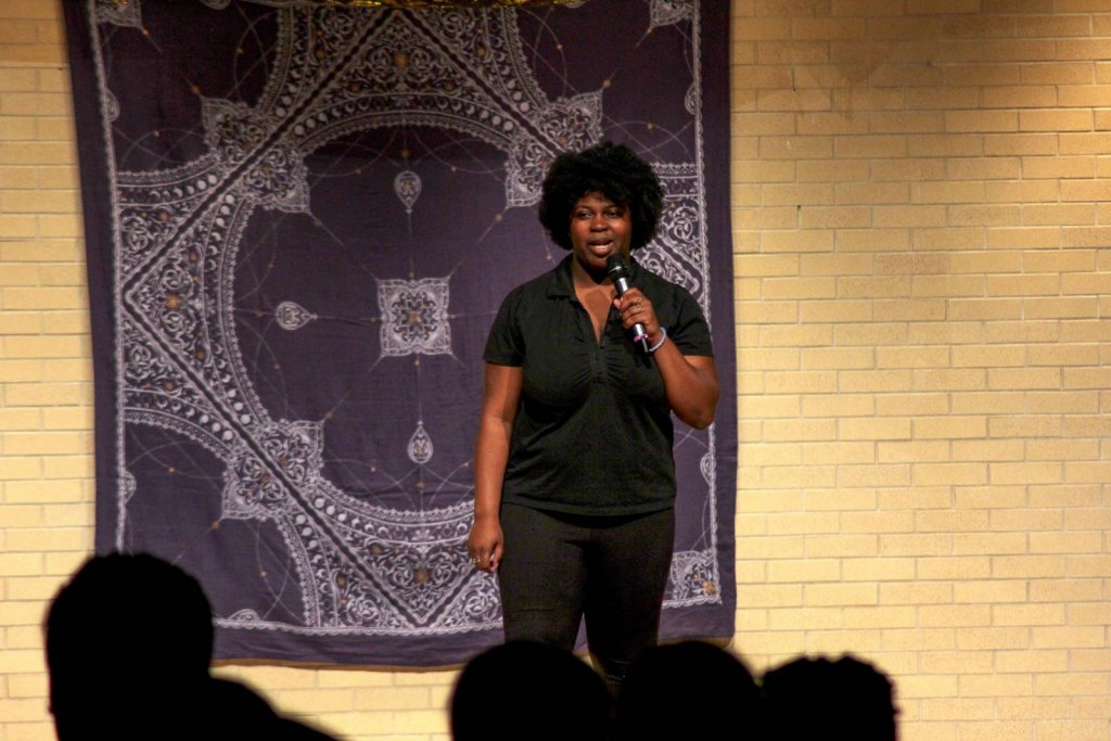 Woman in black shirt speaking into a microphone