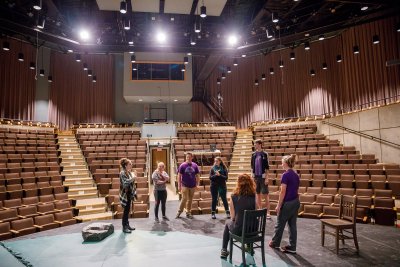 Students and instructor standing on a theater stage