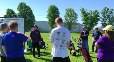 Students at a golf course listening to a presentation