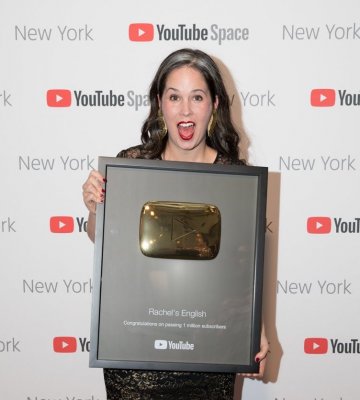 Woman holding a YouTube Gold Creators Reward in front of a 