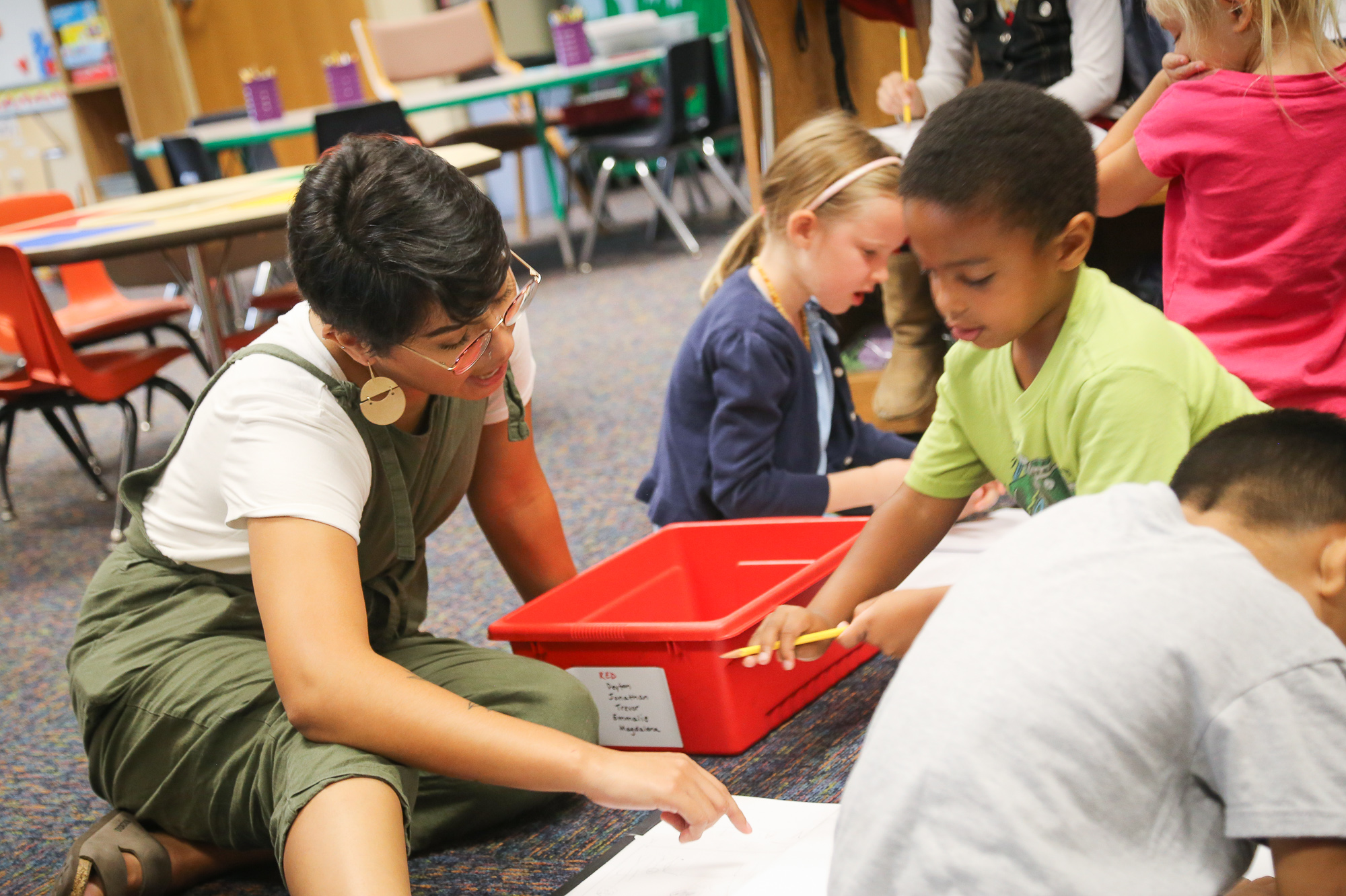 Student sitting and working with elementary grade students