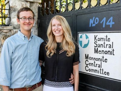 Couple posing next to a black gate with 