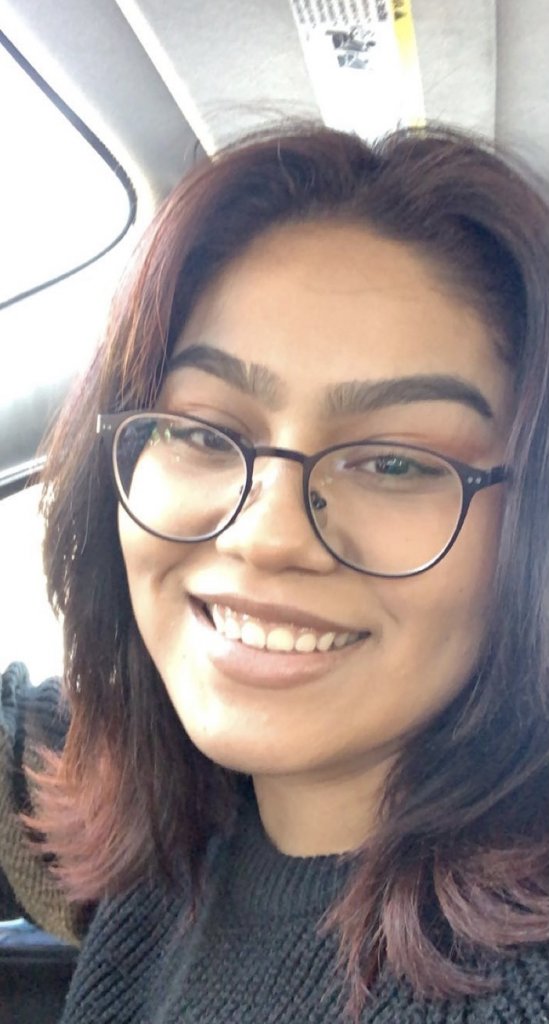 Woman in black shirt, glasses smiling