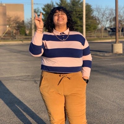 Woman in purple and pink striped shirt smiling.