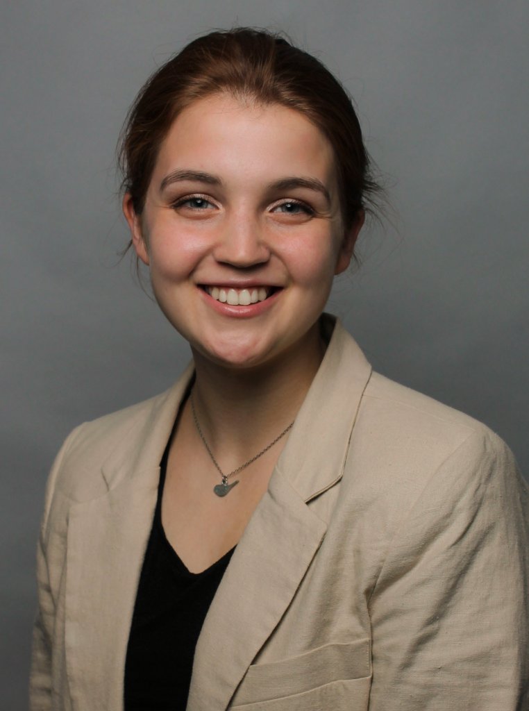 Woman in a tan jacket smiling