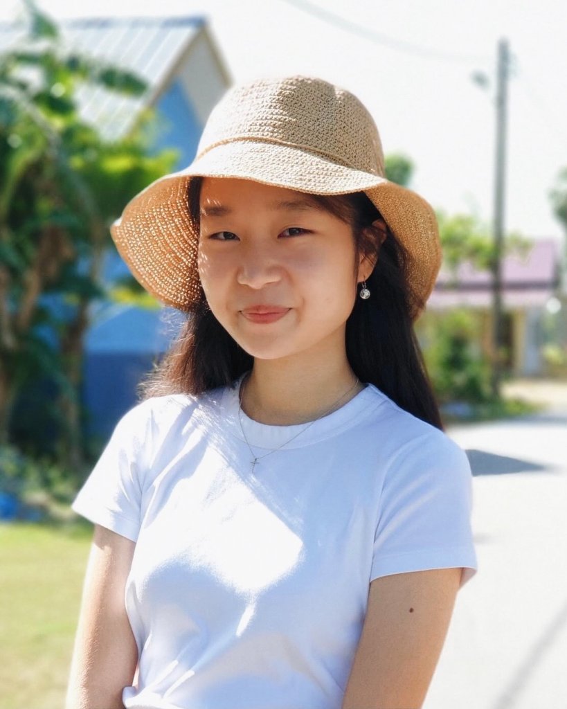 Woman in white t-shirt, sun hat smiling