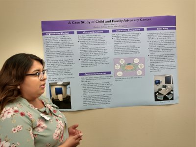 Sabrina presenting at academic symposium poster