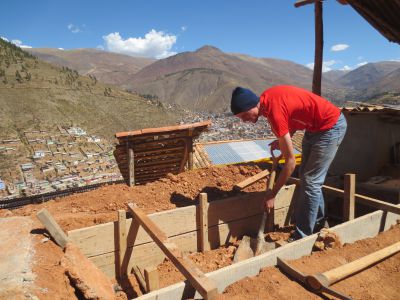 After digging a  hole of the correct dimensions, Luke helps build a wooden form inside