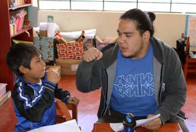 Jacob shares a fist bump with a student for a job well done.