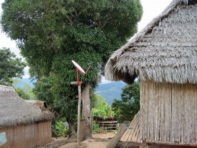 A typical modern juxtaposition: a satellite dish by a bamboo home.