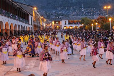 A large group of women sing and dance their way by the Plaza de Armas.