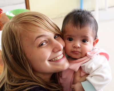 Aimee cuddles with a cute baby in the orphanage.