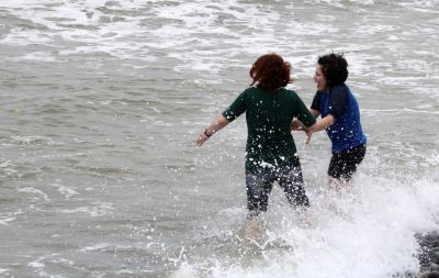 A wave surprises Sierra and Edith.