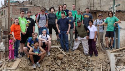 Goshen College students pause for a final photo at the Anglican mission in Puente Piedra with Pastor Benjamin Salas Aguirre and his wife, Livia.