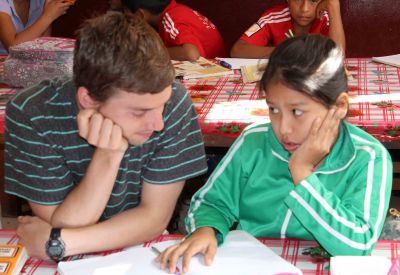 Stefan helps a child with her home work.