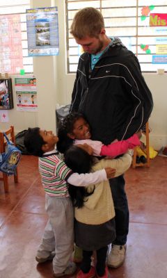 First-grade students hug Matt.