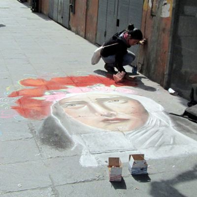 A street artist offers a chalk rendering of St. Rosa. 