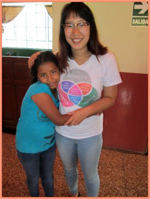 Shina receives a hug from a student at INABIF, her school in San Ramon.