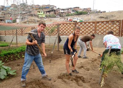 Micah, Jo and Ike take their turn at working the sandy soil in a Villa Maria community garden.