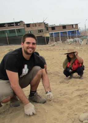 Zach helping a community gardener prepare soil for planting in Lima.