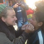 Hayley paints the teeth of a young student with flouride.