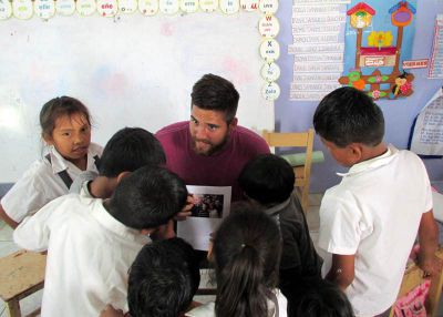 Zach shows his students photos of friends and family in the United States.