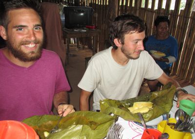 Zach and David dig into a delicious lunch of chicken and yuca wrapped in flavorful leaves.