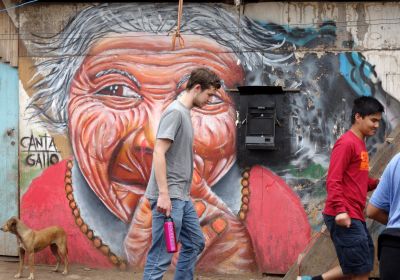 Tim walks in front of one of the neighborhood's many murals.