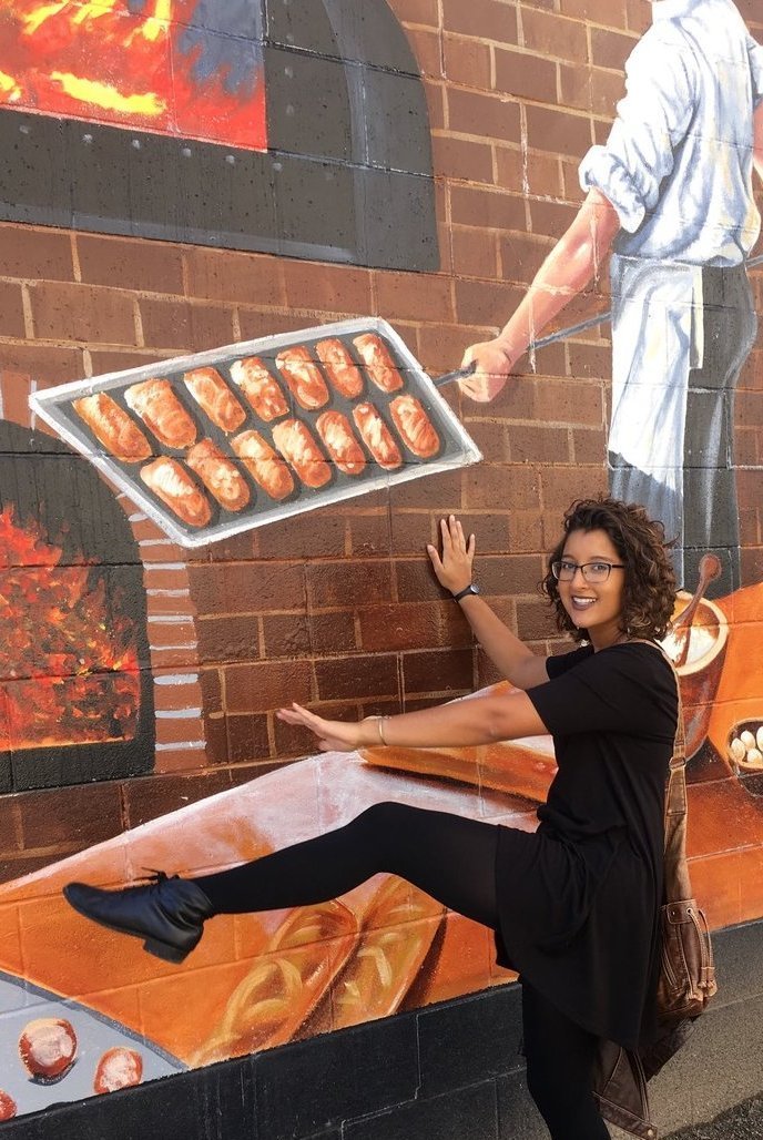 Student with bakery mural in Detroit